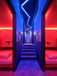 a hallway with red and blue lights and stairs at The Hyve Capsule Amsterdam in Amsterdam