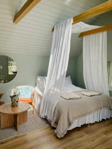 a bedroom with a canopy bed and a table at Cabin With Private Beach At Ingarö in Skenora