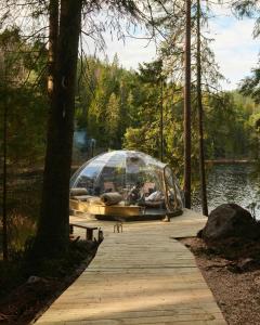 a boat in a glass dome on a dock at Magical Igloo By The Water In Helgeroa in Larvik
