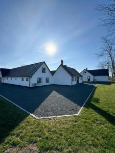 una gran casa blanca con un gran patio en Traditional Farmhouse In The Heart Of Österlen, en Gärsnäs