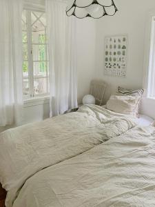 a white bed in a bedroom with a window at Swiss-Style Villa With Forest Views Near Bråviken in Norrköping