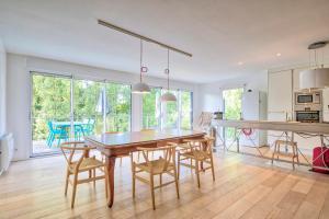 eine Küche und ein Esszimmer mit Tisch und Stühlen in der Unterkunft Renovated Chalet In The Heart Of Nature In Vendée in La Gaubretière + 10 Fotos