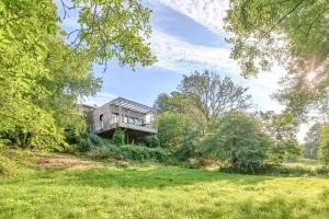 ein Haus mitten auf einem Feld mit Bäumen in der Unterkunft Renovated Chalet In The Heart Of Nature In Vendée in La Gaubretière