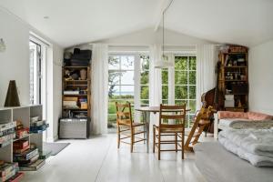 a living room with a table and chairs at Island Life Gem With All Heart Desires in Kragenæs