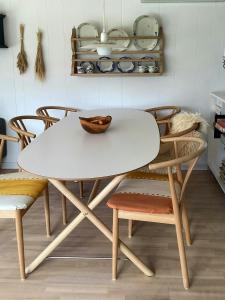 a white table and chairs in a room with plates at Family House With Large Garden Near Ebeltoft in Ebeltoft +8 photos