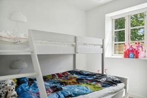 a white bunk bed in a room with a bunk bedutenewayangering at Enjoy Møn From Historic House in Stege
