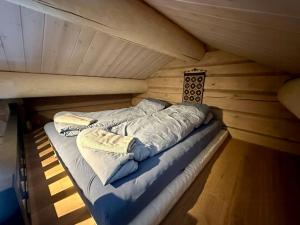オップダールにあるSpacious Mountain Cabin With Lodge Style In Oppdalのキャビン内の木造の部屋のベッド1台