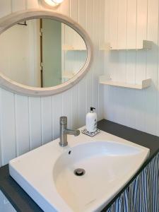 a bathroom with a white sink and a mirror at Forest Cabin With Panoramic View Near Blokhus in Blokhus