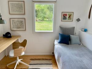 MelbyにあるNew Nordic House Near Liseleje Beachのベッドと机と窓のある寝室