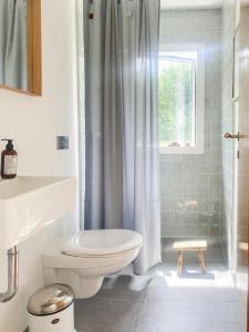 MelbyにあるNew Nordic House Near Liseleje Beachのトイレとシャワー付きの白いバスルーム