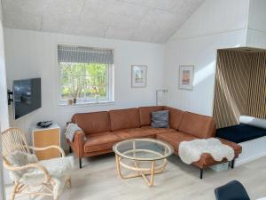 una sala de estar con un sofá y una mesa en Cozy Summer House Near Beach And Town, en Søndervig