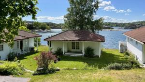 a house on the shore of a body of water at Cabin With Sunset Views And Private Dock in Sandefjord