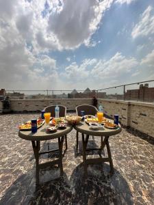 two tables with food and drinks on a patio at Al lord for Tourism in Cairo