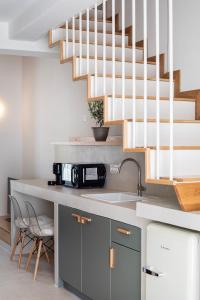 a kitchen with a sink and a staircase at Olive Dryopis Apartments in Kithnos