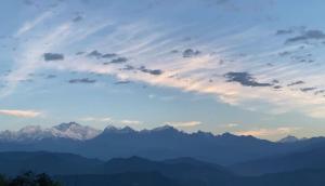 a cloudy sky with mountains in the background at Madhuchuli Homestay in Darjeeling