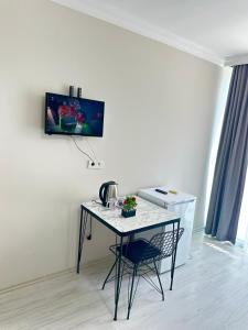 a table with a chair and a tv on a wall at Upart Flats by REFE in Antalya