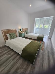 two beds in a room with two windows at Estoril House in Estoril