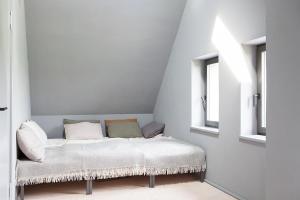 a bed in a room with two windows at Architectural Gem On The Cornfield in Lindenhagen