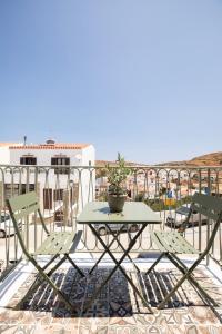 a table and chairs on a balcony with a view at Olive Dryopis Apartments in Kithnos