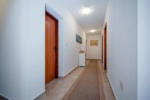 a hallway with white walls and a door at Ladonja bed & breakfast in Rovinjsko Selo