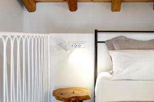 a bedroom with a bed and a wooden stool next to a bed at Olive Dryopis Apartments in Kithnos