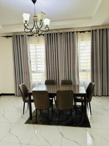 mesa de comedor con sillas y lámpara de araña en Gabstel Apartments, en Kitwe 13 fotos más