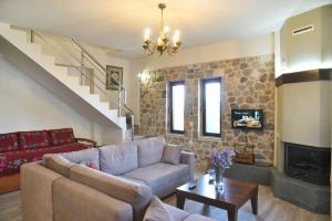 a living room with a couch and a fireplace at Helena's House in Ipáti