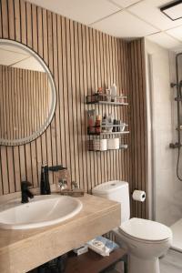 un bagno con lavandino, WC e specchio di Amazonia City Center a Torremolinos