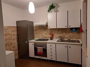 a kitchen with white cabinets and a stainless steel refrigerator at Oasi Pieve in Pian di Scò