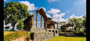 a wooden cabin with a stone wall and a bench at Poeme Chalet in Râșca +27 photos