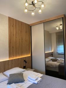 a bedroom with a mirror and a bed with towels on it at Titova Vila - Golden Peak Residence in Zlatibor +9 photos