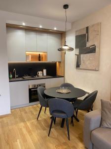 a living room with a table and chairs and a kitchen at Titova Vila - Golden Peak Residence in Zlatibor