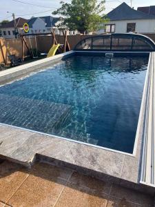 a swimming pool with blue water in a yard at PRÉMIUM APARTMANOK in Kisvárda