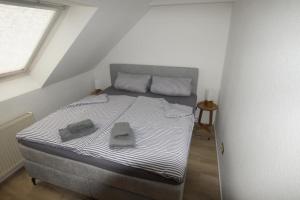 une chambre avec un lit avec deux serviettes dessus dans l'établissement Lüttke Juwel, Ferienwohnung mit traumhaftem Seeblick, à Lembruch