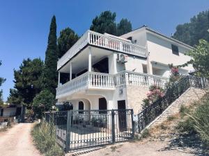 a white house with a balcony and stairs at Villa Luna Blue in Brca