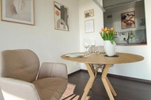 uma mesa com um vaso de flores e uma cadeira em Dümmer Traum-Traumblick auf dem Dümmersee em Lembruch