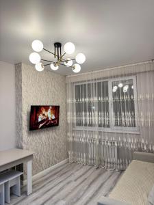 un soggiorno con una TV a parete di Трехкомнатная квартира с хорошим ремонтом a Almaty Altre 2 foto