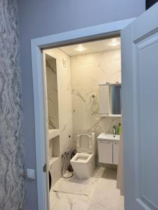 un bagno con un water bianco e un lavandino di Трехкомнатная квартира с хорошим ремонтом a Almaty