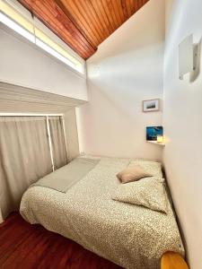 a small bedroom with a bed and a window at Le 140, Surf et Confort in Seignosse +10 photos