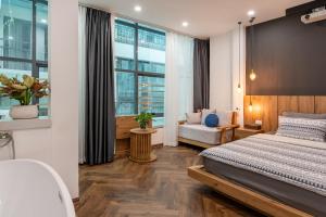 a bedroom with a bed and a couch and a window at Hanoian Hearths - 5 Bedrooms - Bath Tubs - Projectors in Hanoi