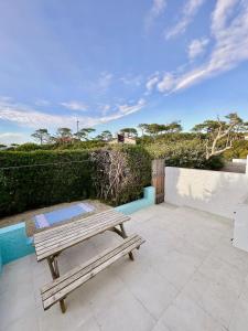 a picnic table on a patio with a view of the ocean at Le 140, Surf et Confort in Seignosse