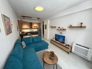 a living room with a blue couch and a television at Flat in Orikum Beach in Orikum