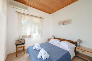 a bedroom with two towels on a bed at To Pournari Beachside Garden House - Happy Rentals in Korakokhórion
