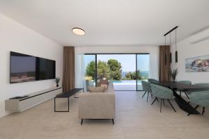 a living room with a television and a table and chairs at Cloud 9 D4 in Tkon