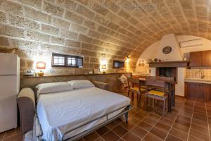 a bedroom with a bed in a stone wall at La Macchia del Salento in Baia Di Gallipoli
