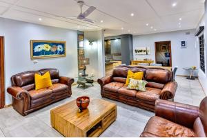 a living room with leather couches and a coffee table at RR001 Robbins Road - A home away from home in Ballito
