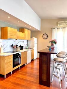 a kitchen with wooden cabinets and a counter top at Appartement vue mer Christophe Colomb 140m2 in Calvi