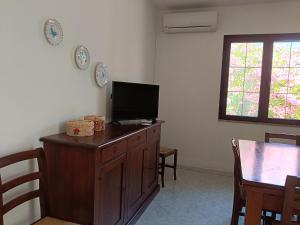 a living room with a television on a wooden dresser at Bilo Lu Rattali in San Teodoro +34 photos