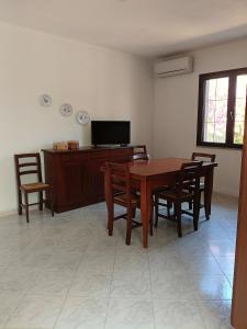 a dining room with a wooden table and chairs at Bilo Lu Rattali in San Teodoro