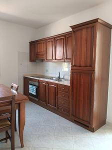 a kitchen with wooden cabinets and a table and a sink at Bilo Lu Rattali in San Teodoro